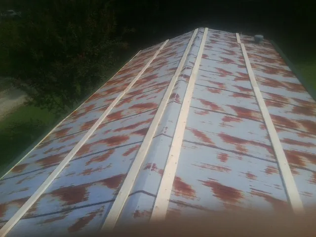 Rusted metal roof panels with new wood purlins before replacement — Storm Damage Roof Repair in Farwell by Roofing Brothers