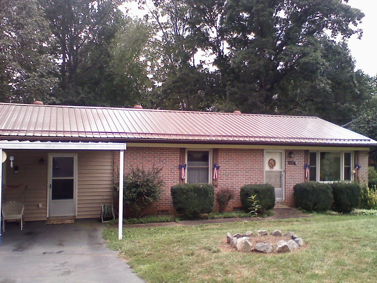 Bronze metal roof and carport on a brick ranch home — Roof Repair work by our crew in Farwell